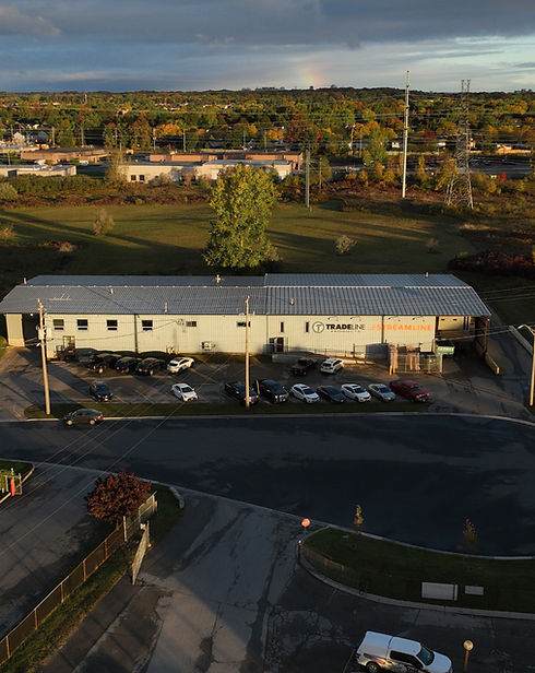 An aerial view of a building with cars parked in front of it showcasing custom metal fabrication.
