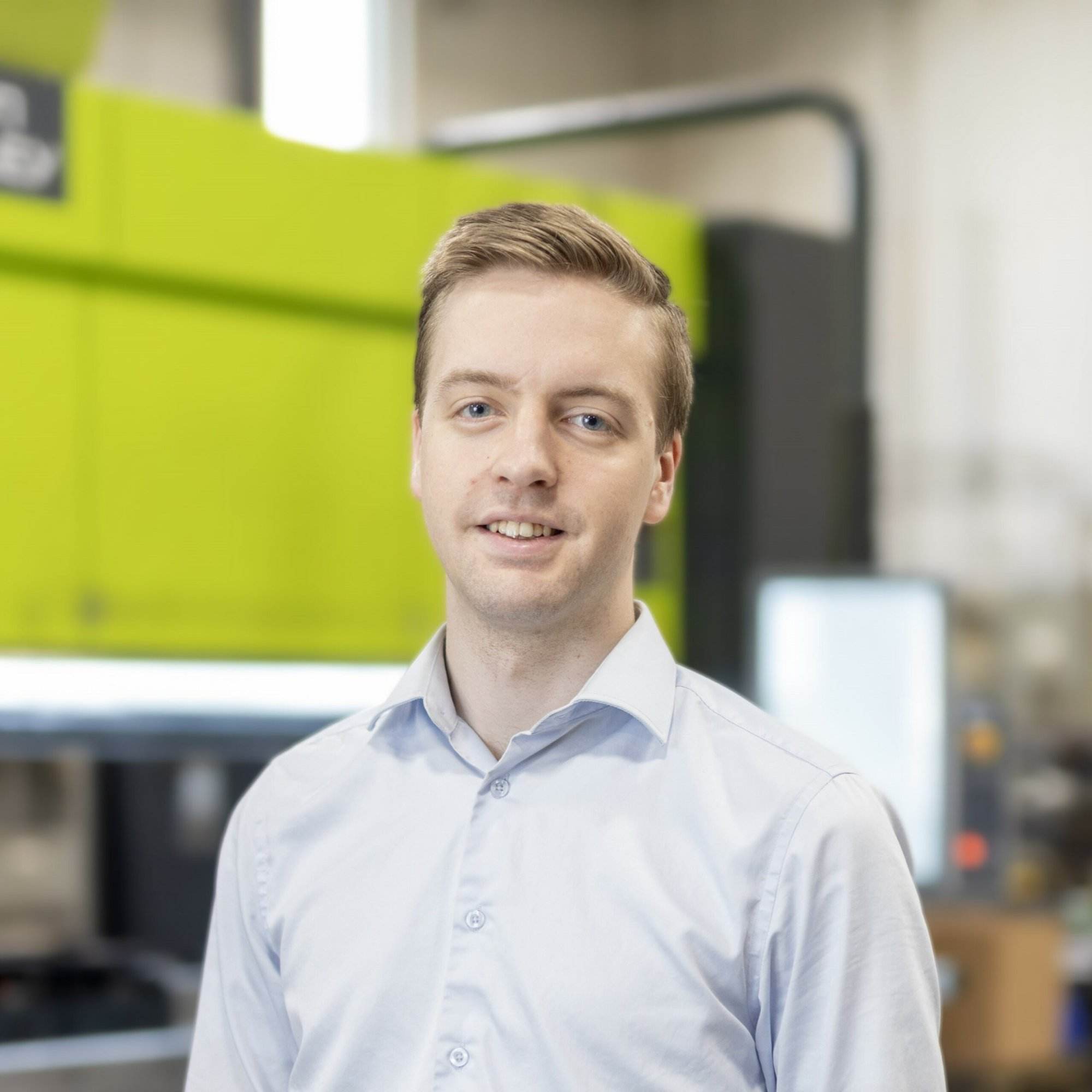 A man standing in front of a custom metal fabrication machine.